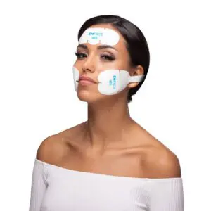 Woman wearing at-home facial toning device pads