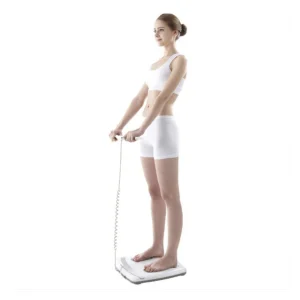 Young woman using digital body composition scale