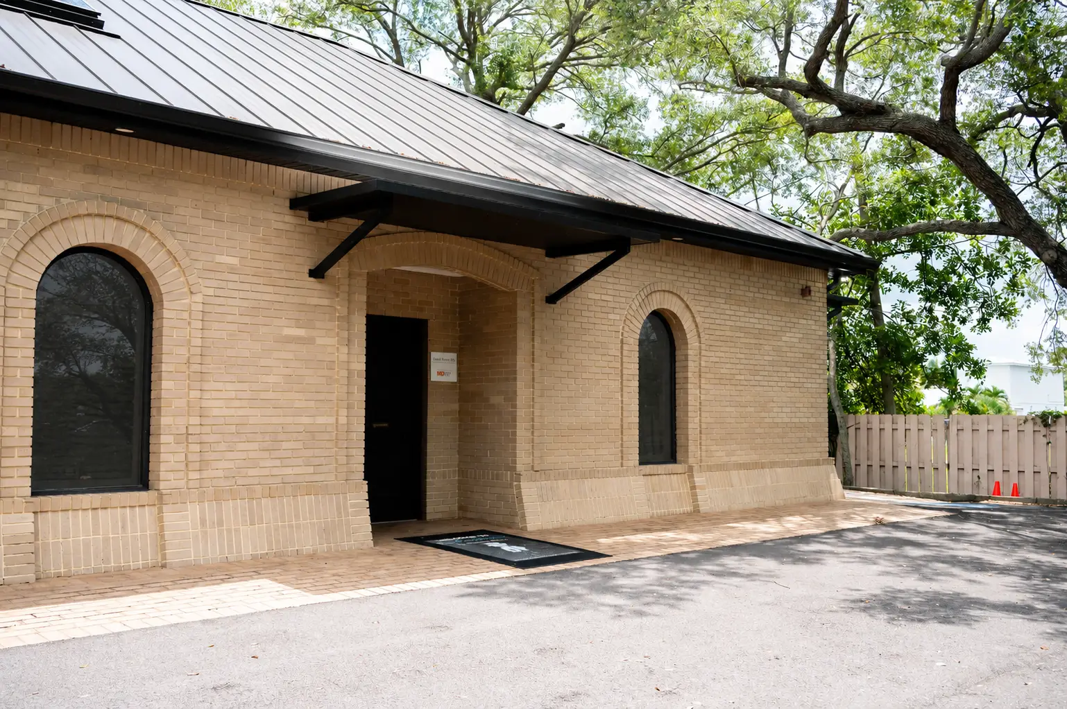 Light brick commercial building with trees