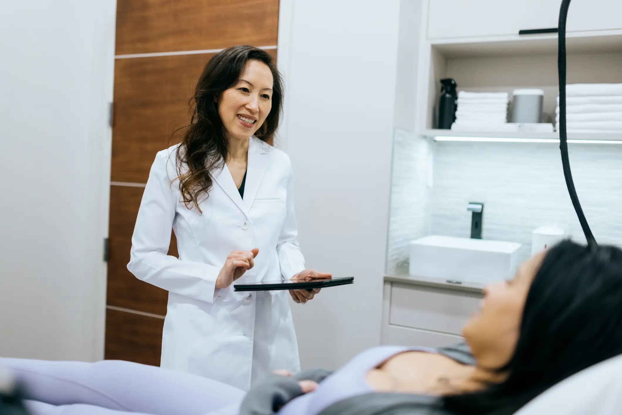 Doctor consulting patient with tablet in clinic