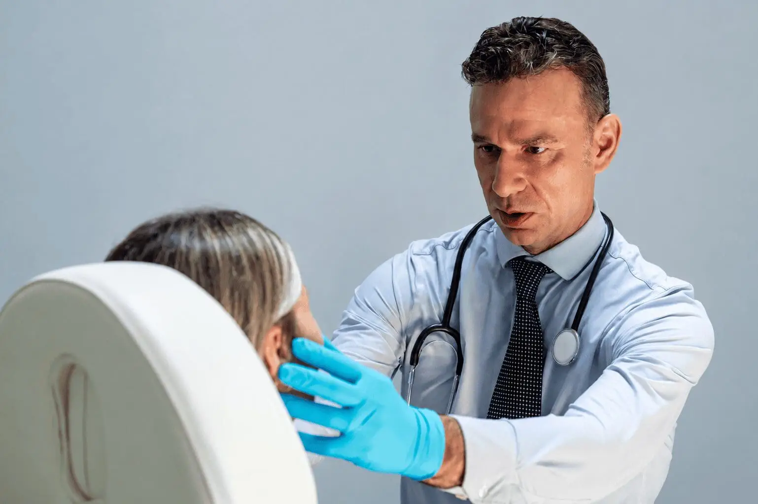 Physician checking patient's face